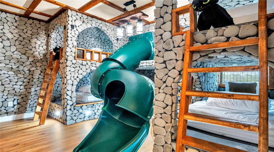 Toothless & Berk's Hideaway. Handcrafted rockwork, custom dragon-inspired bunks, and an adventurous slide create one of the home's most imaginative guest experiences.