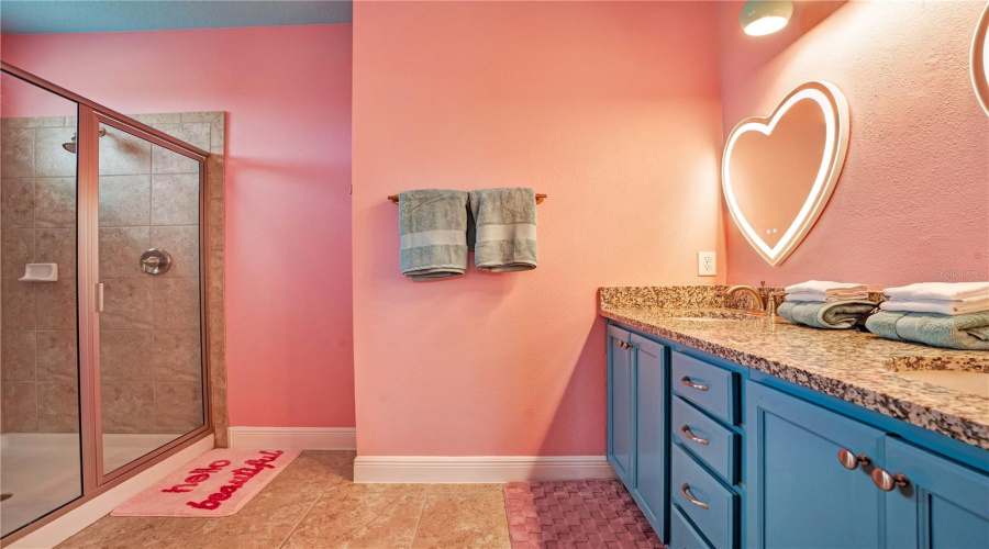 A spacious walk-in shower and colorful custom finishes complete this unforgettable Barbie-themed ensuite.