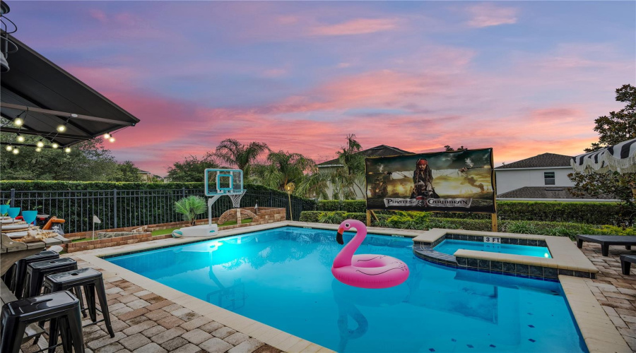 The adventure continues outdoors with a Pirates of the Caribbean-inspired private pool and spa featuring mini golf, outdoor movie screen, mounted speakers, fire pit, covered dining, and multiple spaces to relax under the Florida sun.