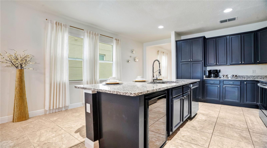 Expansive island seating, generous prep space, wine refrigerator and an open layout allow everyone to gather comfortably while remaining connected to the home's living spaces.