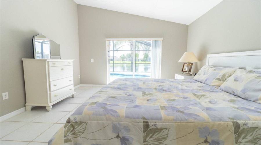 Primary bedroom with pond and pool view