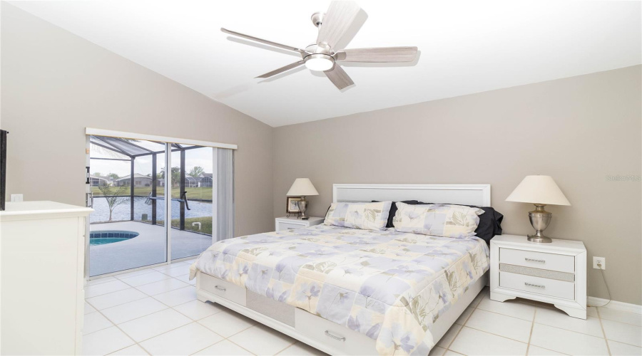 Primary bedroom with pond and pool view