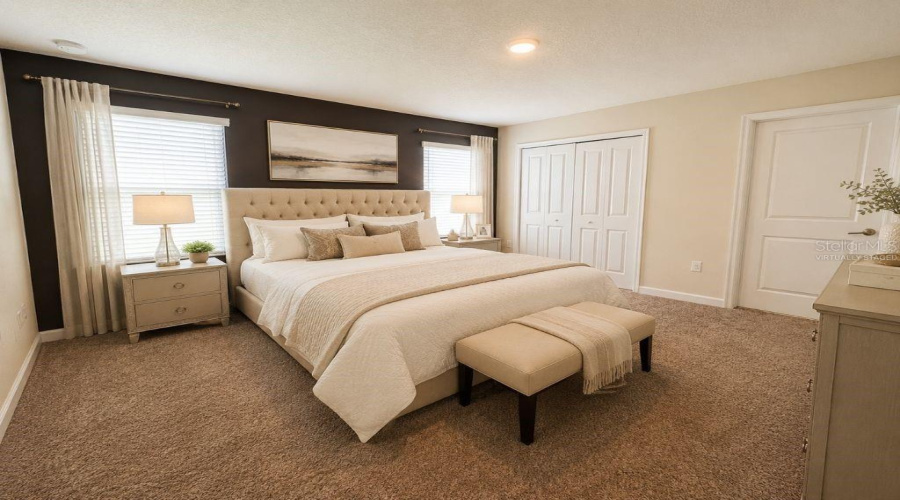 Virtually staged primary bedroom highlighting a spacious, comfortable retreat with neutral finishes, soft natural light, and a relaxing resort-style feel.