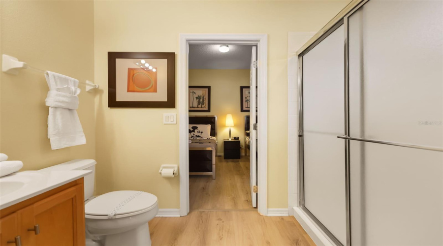 Jack-and-Jill bathroom featuring a large vanity and walk-in shower, conveniently serving the adjoining bedrooms.