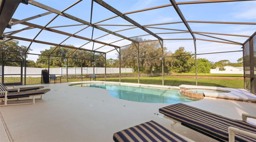 Expansive screened pool enclosure offering ample space to relax, entertain, and enjoy Florida's outdoor lifestyle.