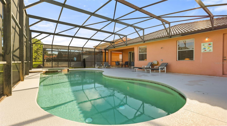 Rear elevation showcasing the screened pool enclosure, covered lanai, and private outdoor living space.