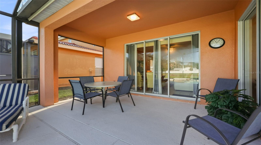 Covered lanai with outdoor dining area, perfect for al fresco meals and relaxing beside the pool.