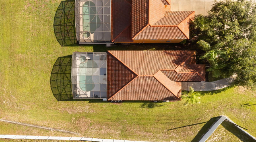 Bird's-eye view of the home highlighting the screened pool enclosure and generous lot size.