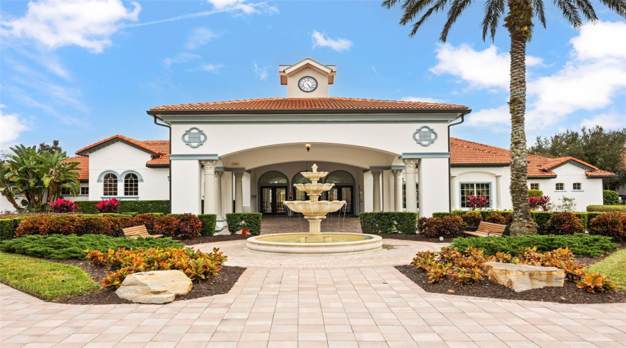 Watersong Resort clubhouse featuring elegant Mediterranean-inspired architecture, a grand covered entrance, and a decorative fountain.