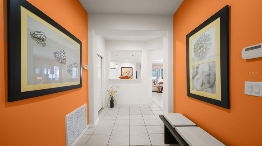 Bright and welcoming foyer offering a spacious first impression with decorative accent walls and an open view into the living area.