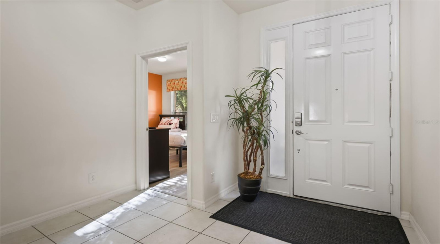Welcoming entry area with high ceilings, abundant natural light, and convenient access to the guest wing.