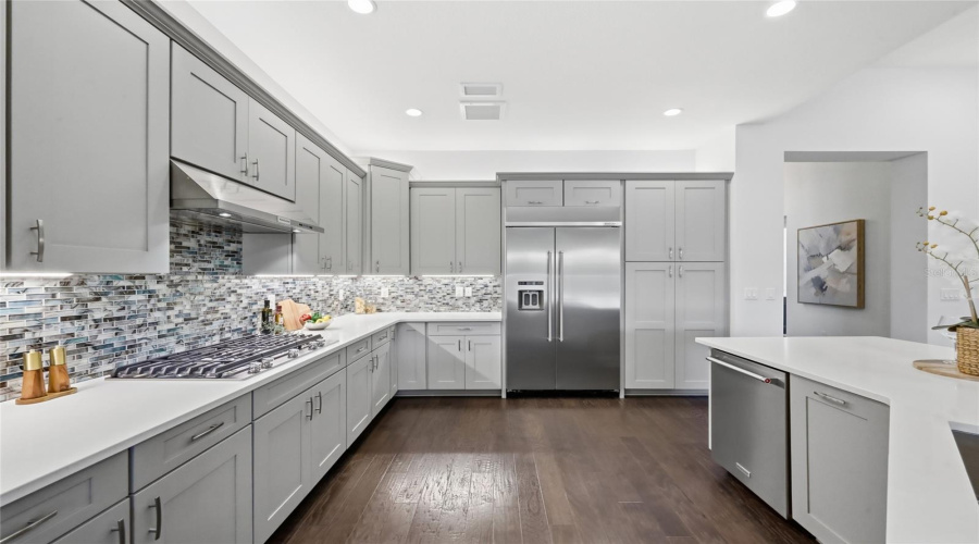 Thoughtfully Designed  Kitchen with Quartz Counter tops, Glass tile Back Splash, Upgraded Natural Gas Range, Upgraded Cabinets, and Oversized Island