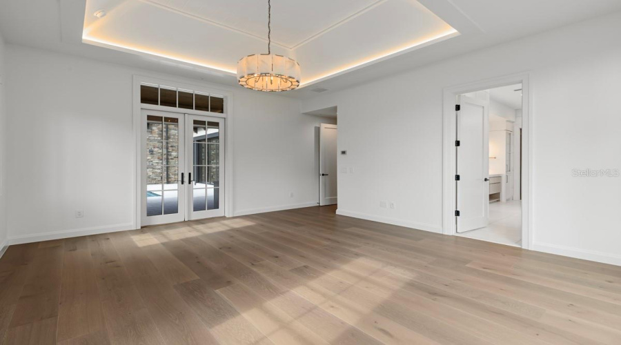 Luxurious primary bedroom with access to outdoor courtyard