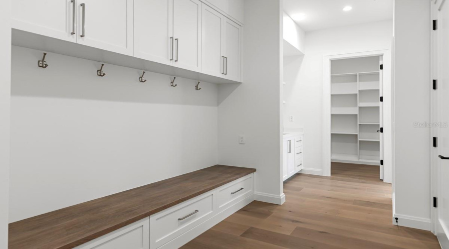 Drop zone area with custom wood cabinetry and shelving
