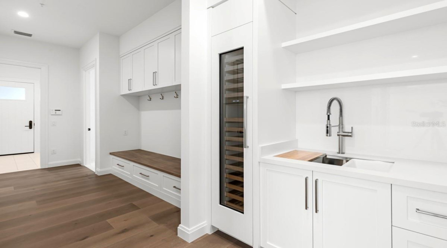 Butler’s pantry directly off kitchen with walk-in pantry featuringcustom-built shelving and cabinetry