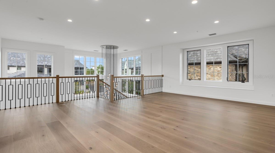 Second-floor loft space adjacent to grand, winding staircaseopens to floor below