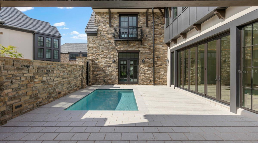 Outdoor living area with summer kitchen and heated lounging pool