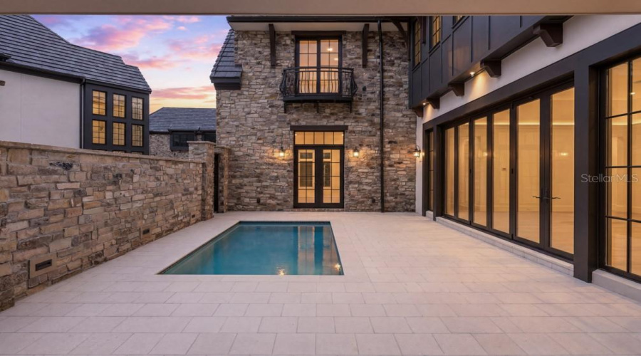 Outdoor living area with summer kitchen and heated lounging pool