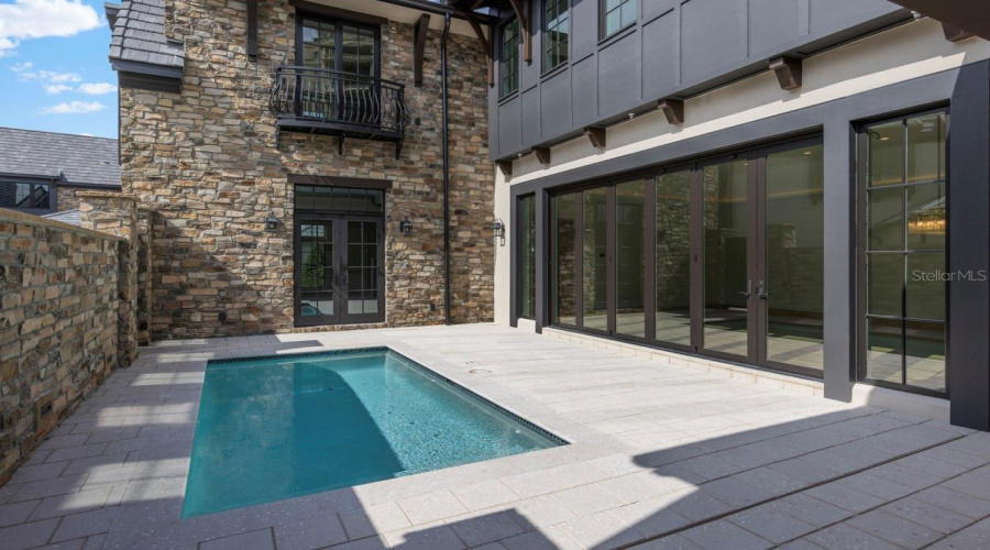 Outdoor living area with summer kitchen and heated lounging pool