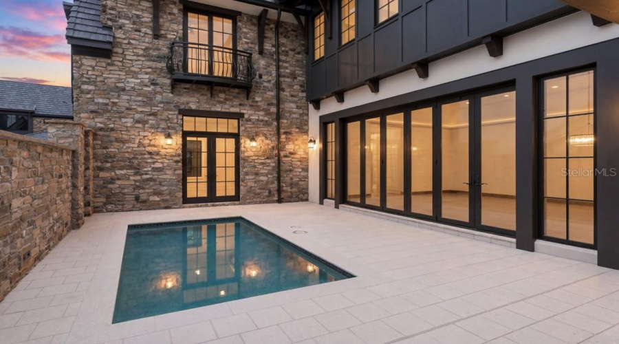 Outdoor living area with summer kitchen and heated lounging pool