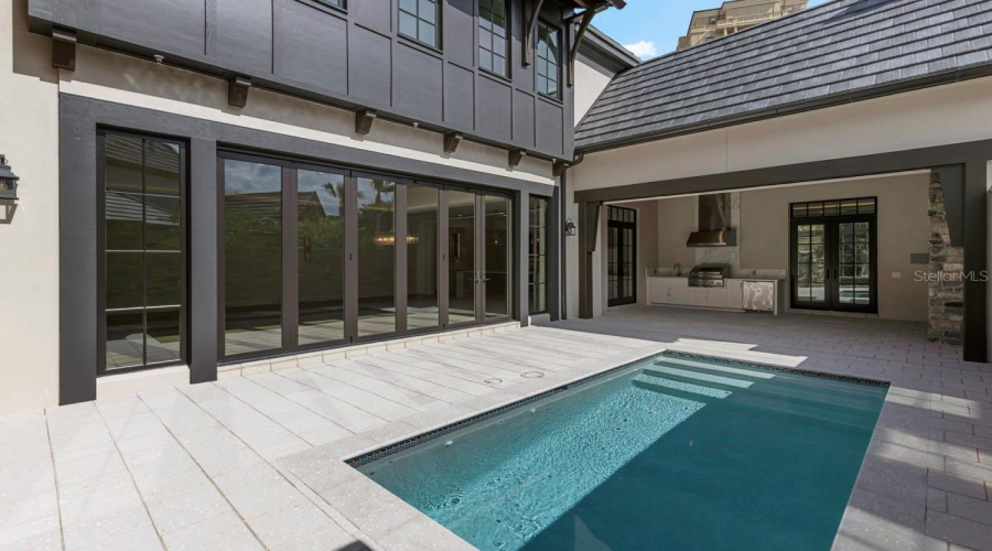 Outdoor living area with summer kitchen and heated lounging pool
