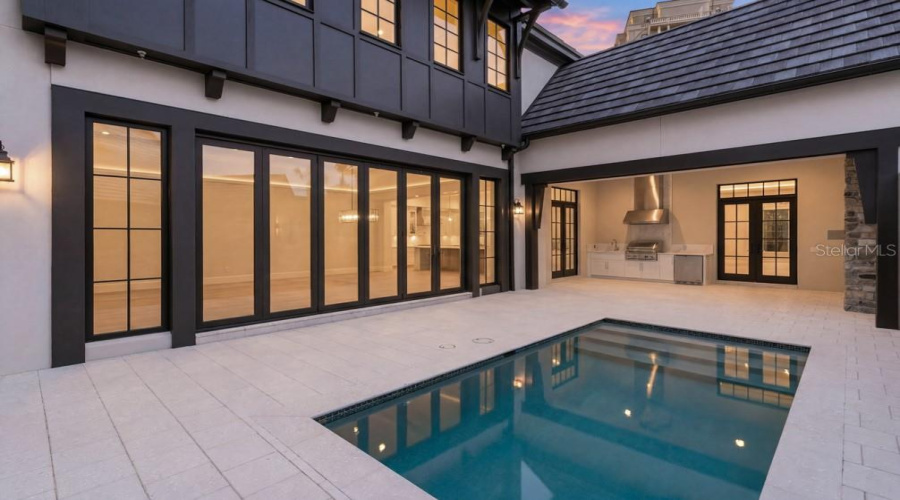 Outdoor living area with summer kitchen and heated lounging pool