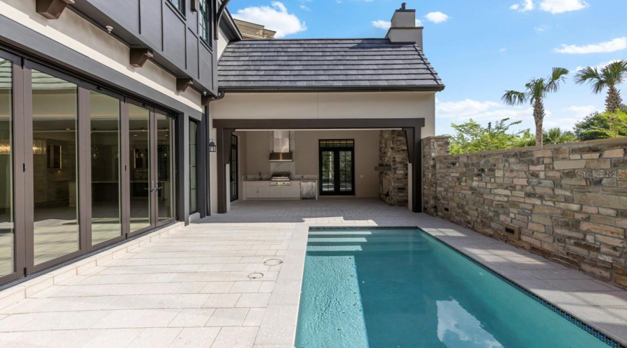 Outdoor living area with summer kitchen and heated lounging pool