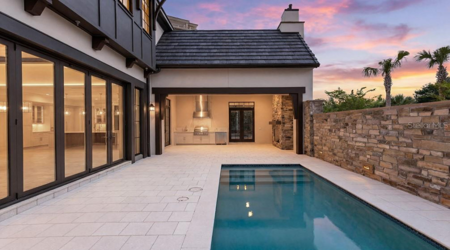 Outdoor living area with summer kitchen and heated lounging pool