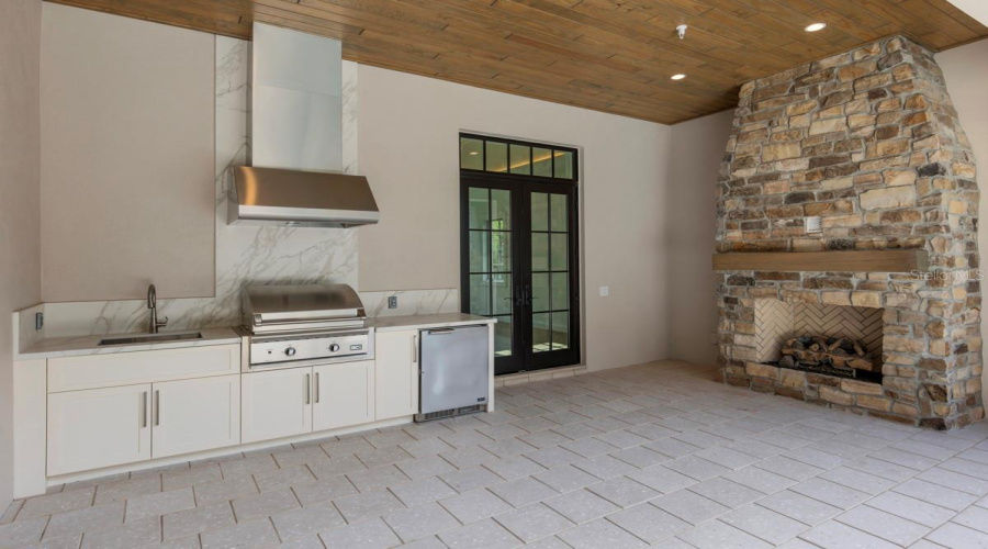Outdoor living area with summer kitchen and heated lounging pool