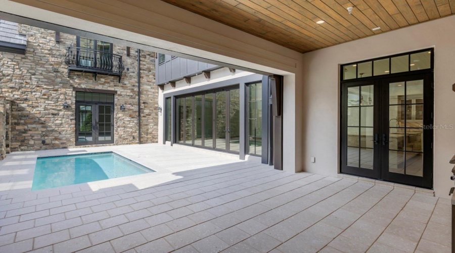 Outdoor living area with summer kitchen and heated lounging pool