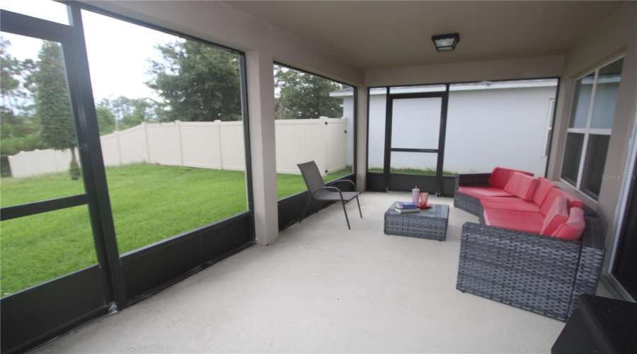 Enjoy a spacious screened-in lanai, offering a cozy outdoor retreat with expansive views of the beautifully landscaped backyard.