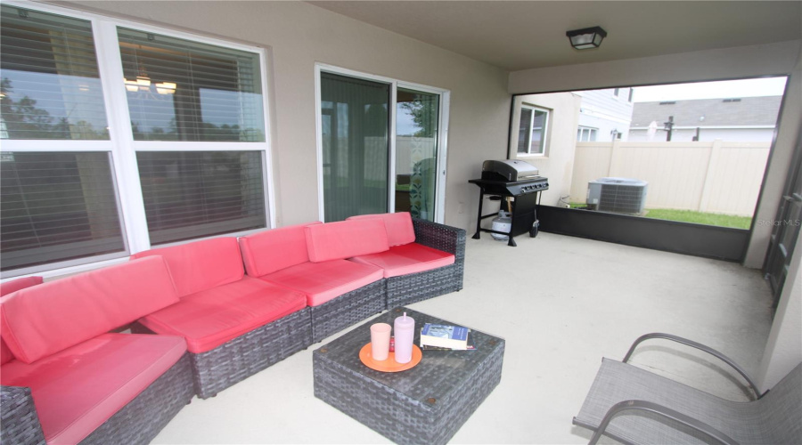 Enjoy a spacious screened-in lanai, offering a cozy outdoor retreat with expansive views of the beautifully landscaped backyard.
