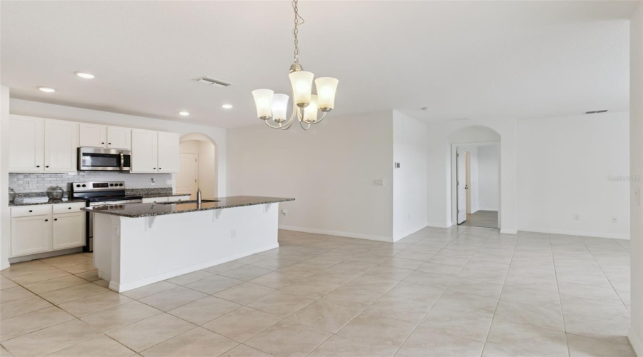 Kitchen Island & Dining Layout:Expansive open layout connecting the central kitchen island and breakfast bar to the dining area and adjacent living spaces.
