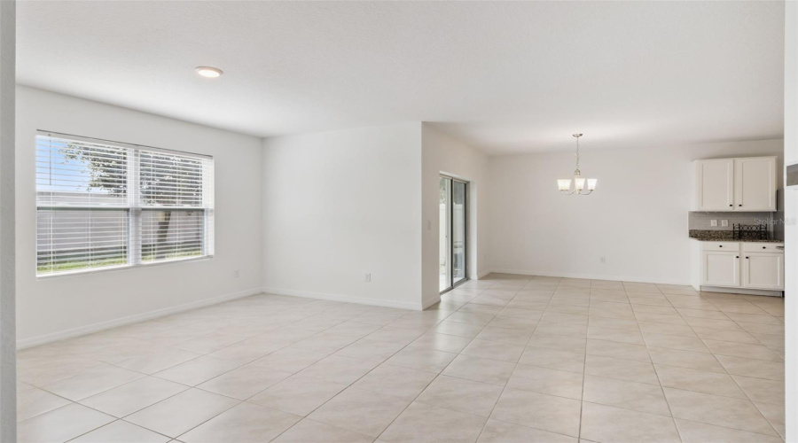 Dining Area & Kitchen Access:Open dining area complete with an elegant overhead fixture, sliding glass doors to the backyard, and easy access to the adjacent kitchen.