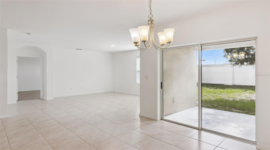 Indoor-Outdoor Flow:Open dining area showcasing seamless indoor-outdoor flow through large sliding glass doors leading directly to the patio.