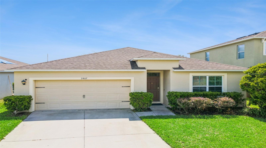 Front Elevation:Charming single-story exterior featuring a paved driveway, two-car garage, pristine stucco finish, and beautifully maintained front landscaping with excellent curb appeal.