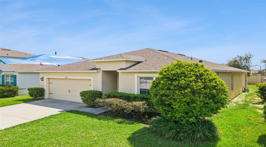 Front Angle:Angled front profile showcasing the property's tidy grounds, clean architectural lines, and lush surrounding shrubbery.