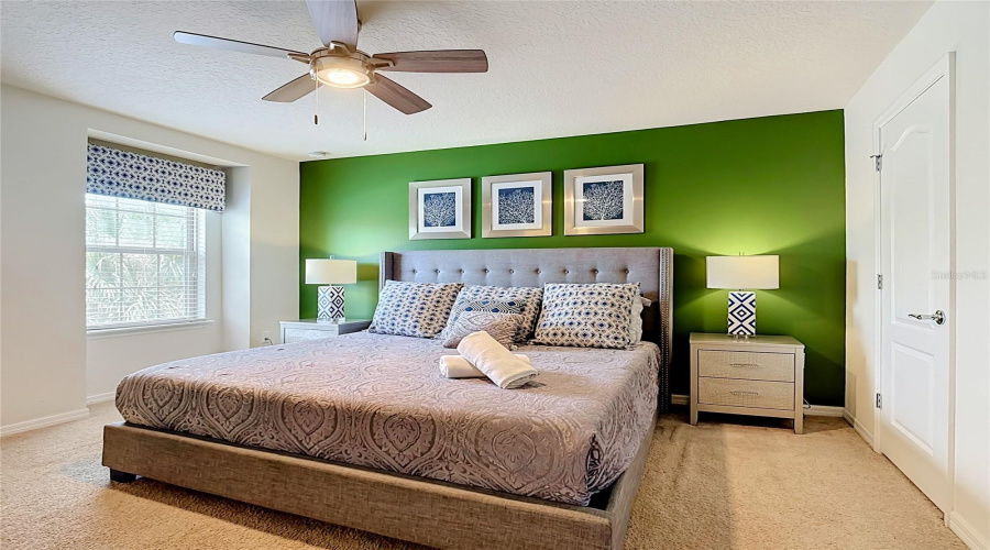 Spacious primary suite with elegant feature wall