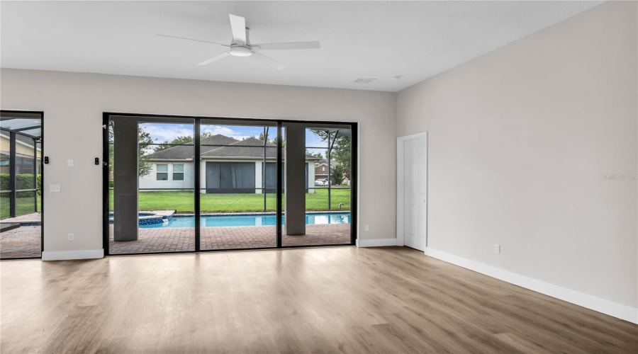 Spacious Family Room with large slider doors that lead to a covered lanai and screen enclosed pool