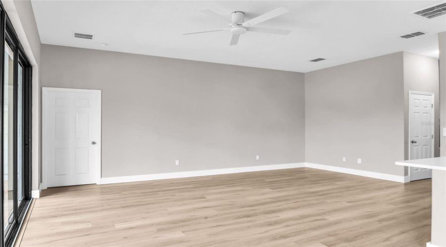 Spacious Family Room with large slider doors that lead to a covered lanai and screen enclosed pool