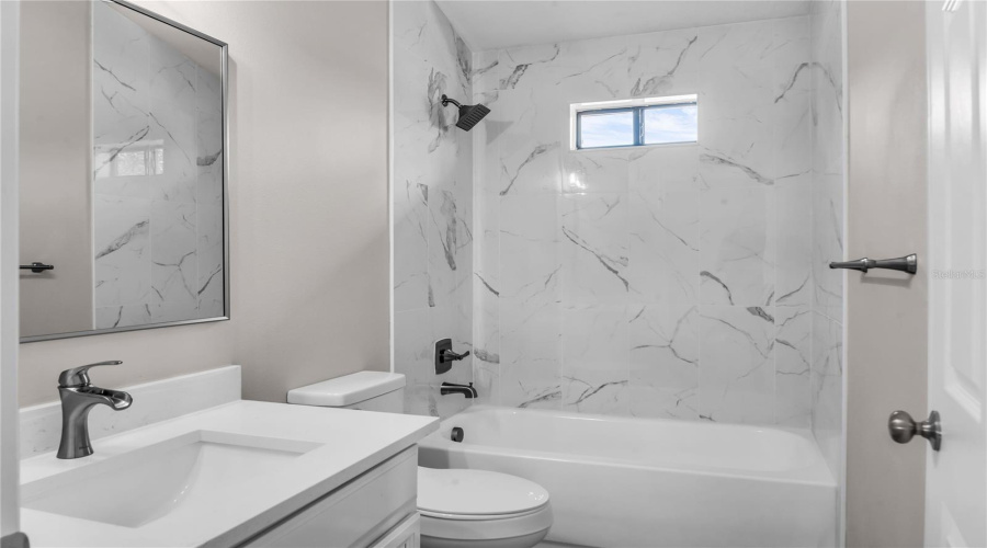 Bedroom 5 ensuite bath with quartz vanity and tiled shower/tub combo