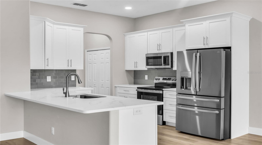 Fully remodeled Kitchen with brand new 42" soft close cabinets, quartz countertops, modern glass tile backsplash, brand new stainless steel appliances, breakfast nook and opens to spacious Family Room and Breakfast Nook