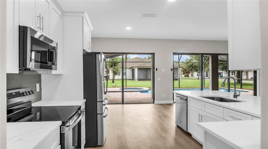 Fully remodeled Kitchen with brand new 42" soft close cabinets, quartz countertops, modern glass tile backsplash, brand new stainless steel appliances, breakfast nook and opens to spacious Family Room and Breakfast Nook