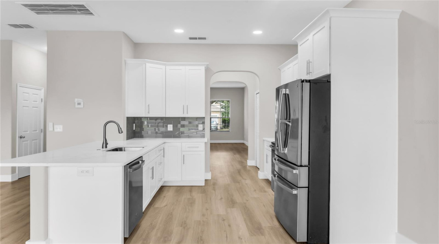 Fully remodeled Kitchen with brand new 42" soft close cabinets, quartz countertops, modern glass tile backsplash, brand new stainless steel appliances, breakfast nook and opens to spacious Family Room and Breakfast Nook