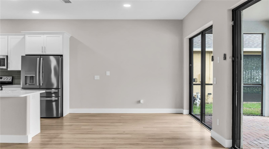 Breakfast Nook opens to Family Room with large slider doors that lead to covered lanai and screen enclosed pool.