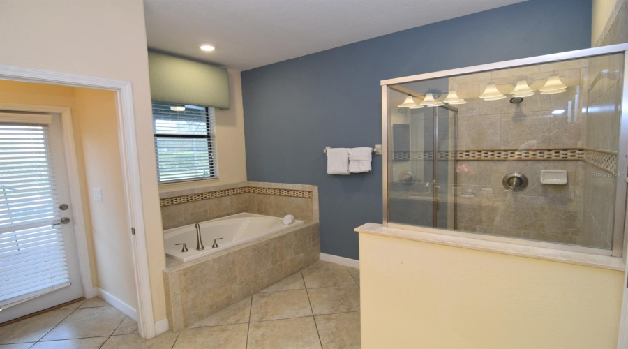 En suite with tub, separate shower, door to pool deck