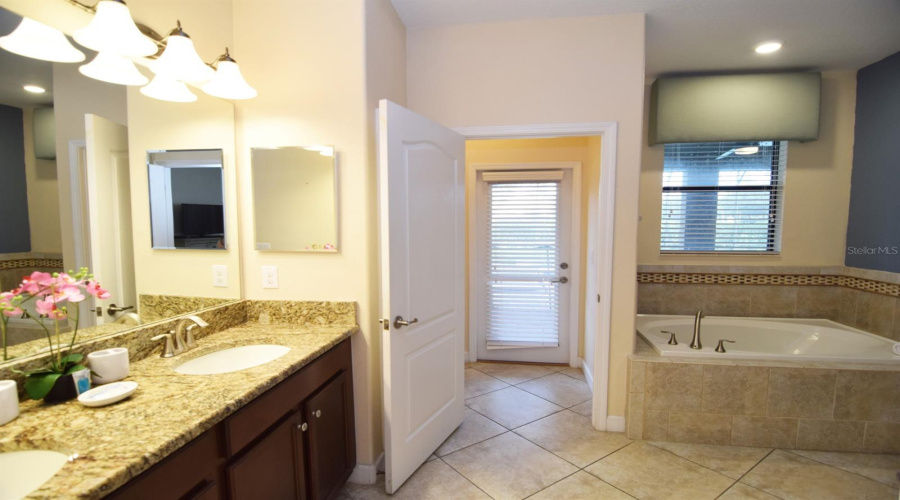 En suite with tub, separate shower, door to pool deck