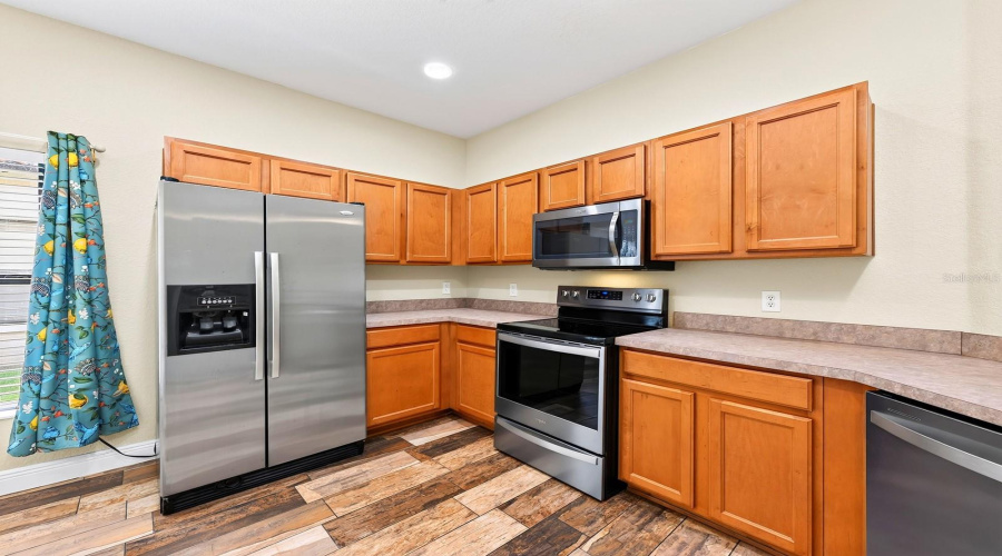The Kitchen features stainless steel appliances, including a NEW WHIRLPOOL STOVE AND DISHWASHER (2023), along with a closet pantry, breakfast bar and sunny BREAKFAST NOOK.