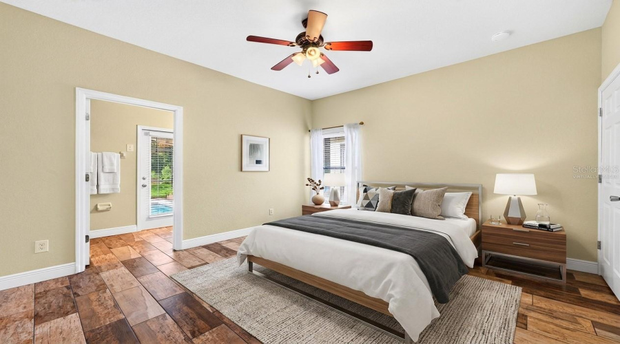 The PRIMARY SUITE is a relaxing retreat with a WALK-IN CLOSET and private en-suite bath, complete with a door providing DIRECT ACCESS TO THE POOL AREA. Virtually Staged