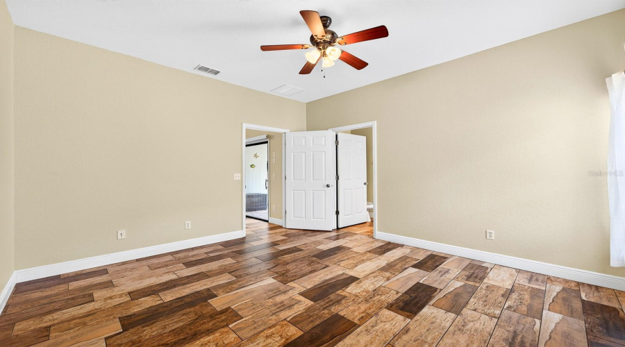 The PRIMARY SUITE is a relaxing retreat with a WALK-IN CLOSET and private en-suite bath, complete with a door providing DIRECT ACCESS TO THE POOL AREA.